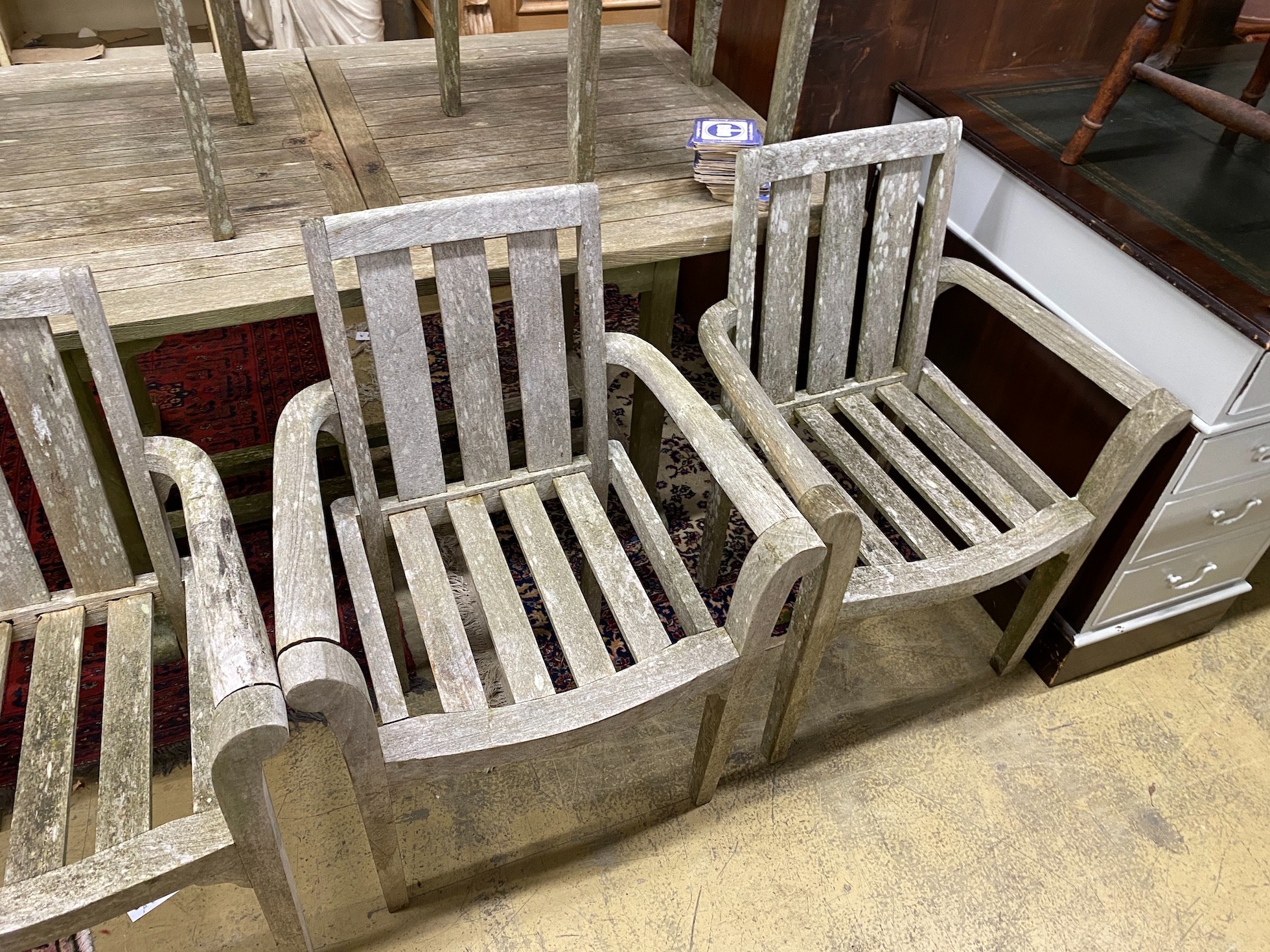 A weathered teak extending table, length 150cm, 90cm unextended and six teak chairs
